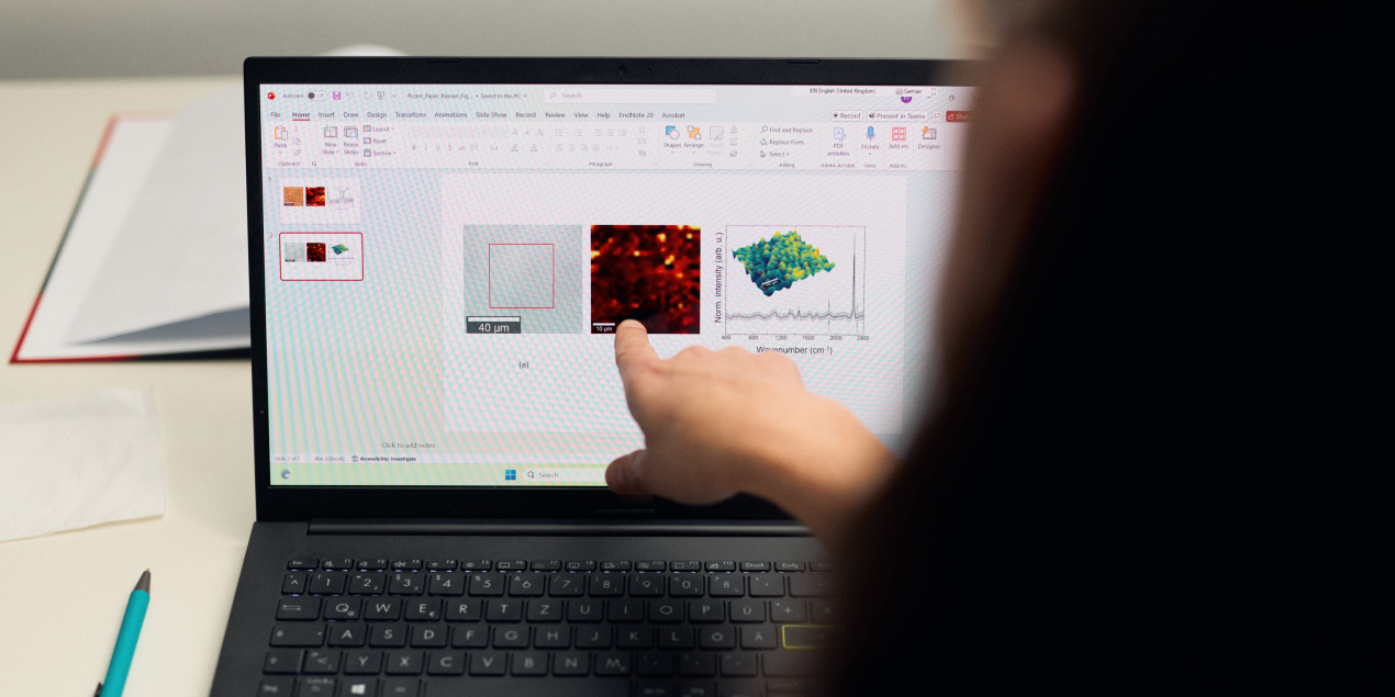 Foto: Elzbieta Stepula zeigt auf verschiedene Grafiken auf einem Laptop
