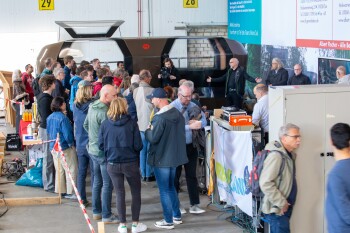 Menschengruppe steht vor dem MONOCAB in der Montagehalle