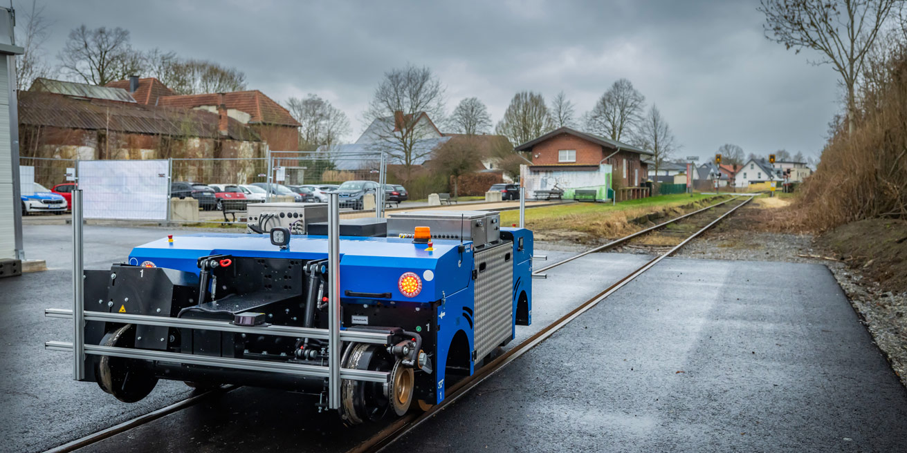 Das Zweiegefahrzeug steht auf den Gleisen am Versuchsfeld