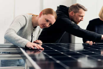 Katharina Schnatmann und Arne Petring begutachten ein PV-Modul auf Schäden