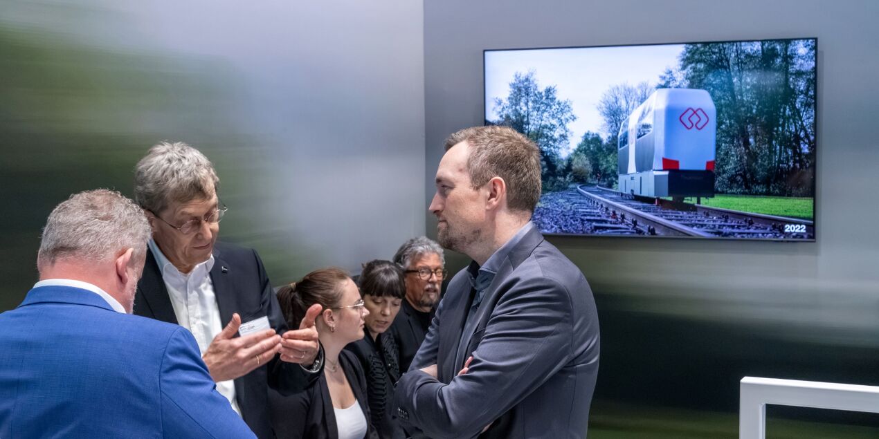 Foto: Prof. Rolf Naumann im Gespräch mit Messebesuchern