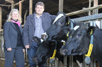 Professorin Schwenzfeier-Hellkamp und Daniel Werner mit zwei Kühen im Kuhstall