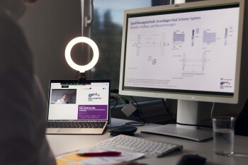 Ein Bildschirm und ein Laptop stehen auf einem Schreibtisch. Auf dem Bildschirm ist zu lesen \