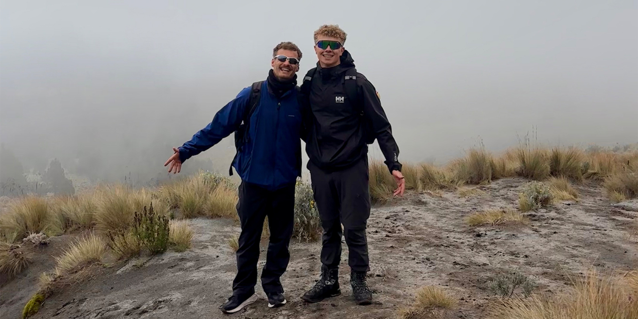 Foto: Zwei Männer stehen in Wanderkleidung neben einem Vulkankrater