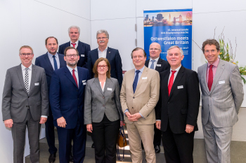 Die Personen stehen vor einem Aufsteller zur Veranstaltung.