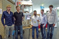 Fünf Studenten stehen vor ihrer Erfindung, einer Cocktailmaschine.