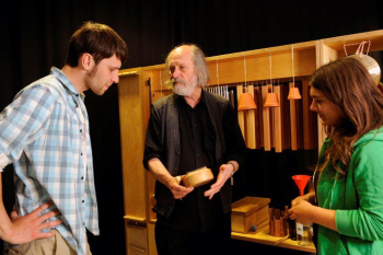 Am Klangregal steht Professor Ausländer mit zwei Studierende