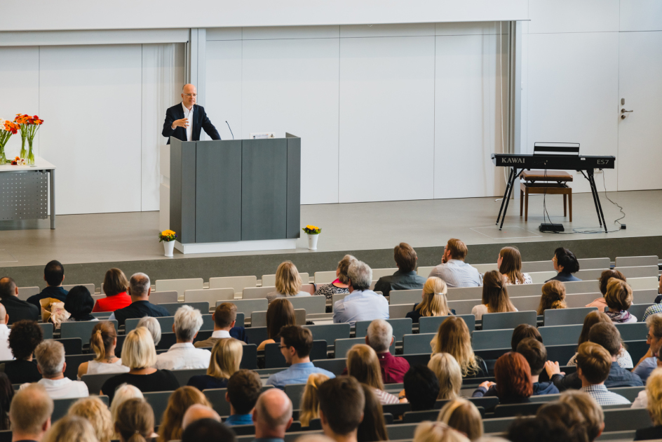 Redner vor dem voll besetzten Hörsaal
