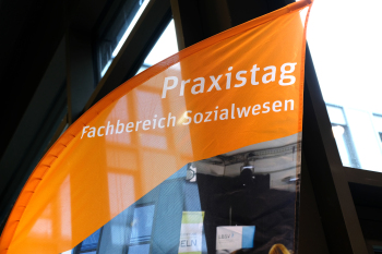 Eine orangene Fahne mit der Aufschrift Praxistag Fachbereich Sozialwesen