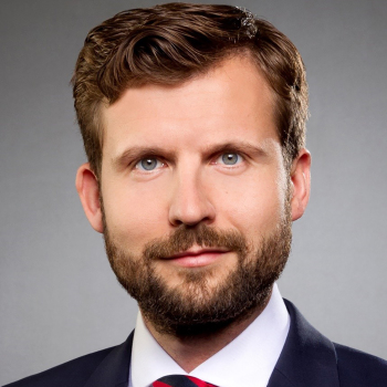 Ein Mann in Anzug schaut in die Kamera