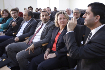 Die Teilnehmer sitzen ine inem Raum und lauschen den Erklärungen eines Mannes im Vordergrund.