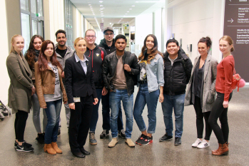 11 Studierende stehen mit Studiengangsleiterin nebeneinander ausgestellt in der Magistrale der FH Bielefeld.