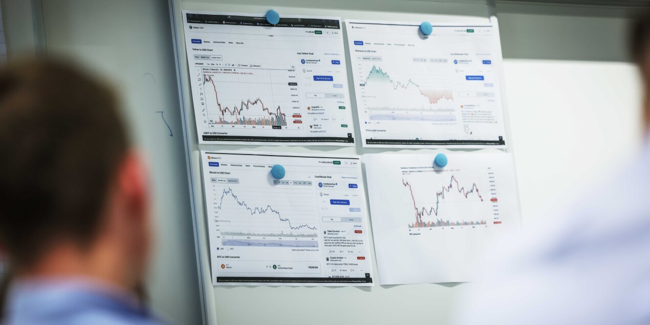 An einer weißen Tafel sind vier Grafiken zum Thema Kryptowährung zu sehen