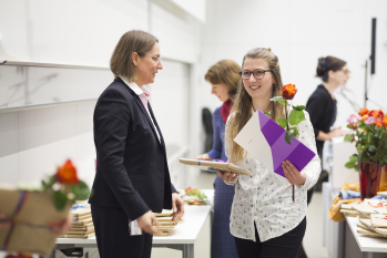 Eoine Absolventin erhält von Prof. Latteck Urkunde, Blume und Geschenk.