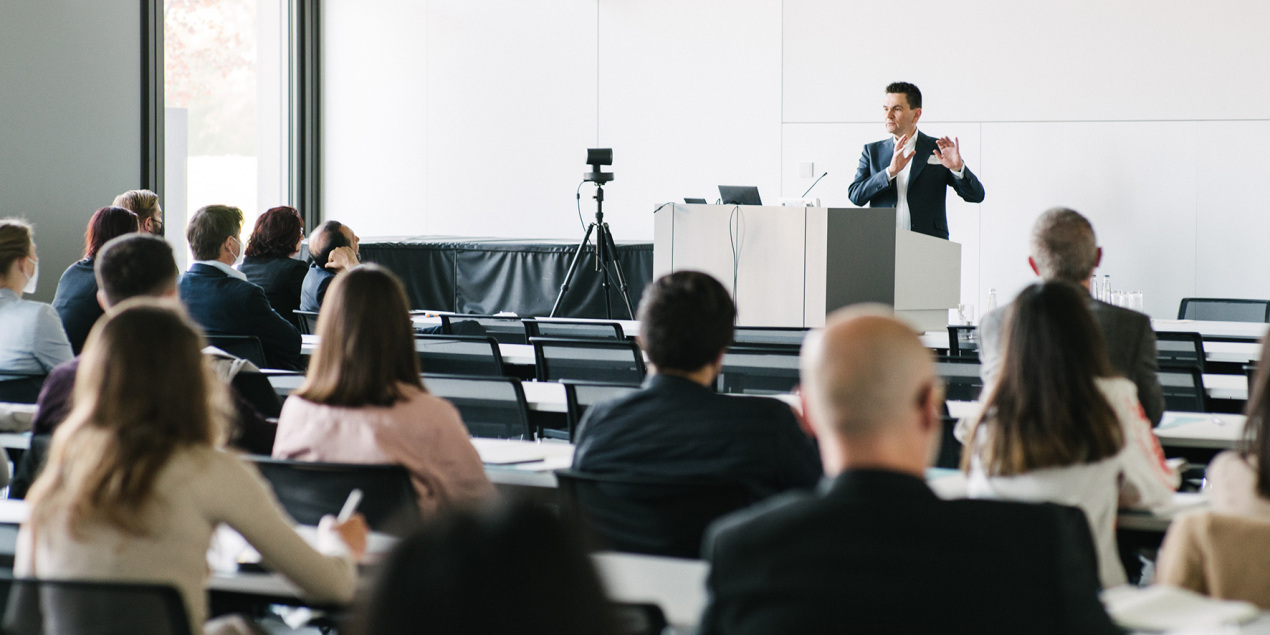 Stefan Breit steht hinter einem Redepult vor Menschen