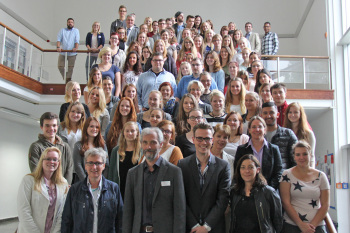 Alle Erstsemester, Professoren und Lehrende stehen auf einer großen Treppe.