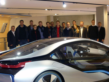 Ein BMW im Vordergrund, Studierende dahinter