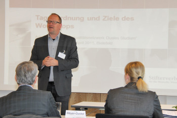 Prof. Beaugrand steht vor einer Leinwand mit einer Power-Point-Präsentation.