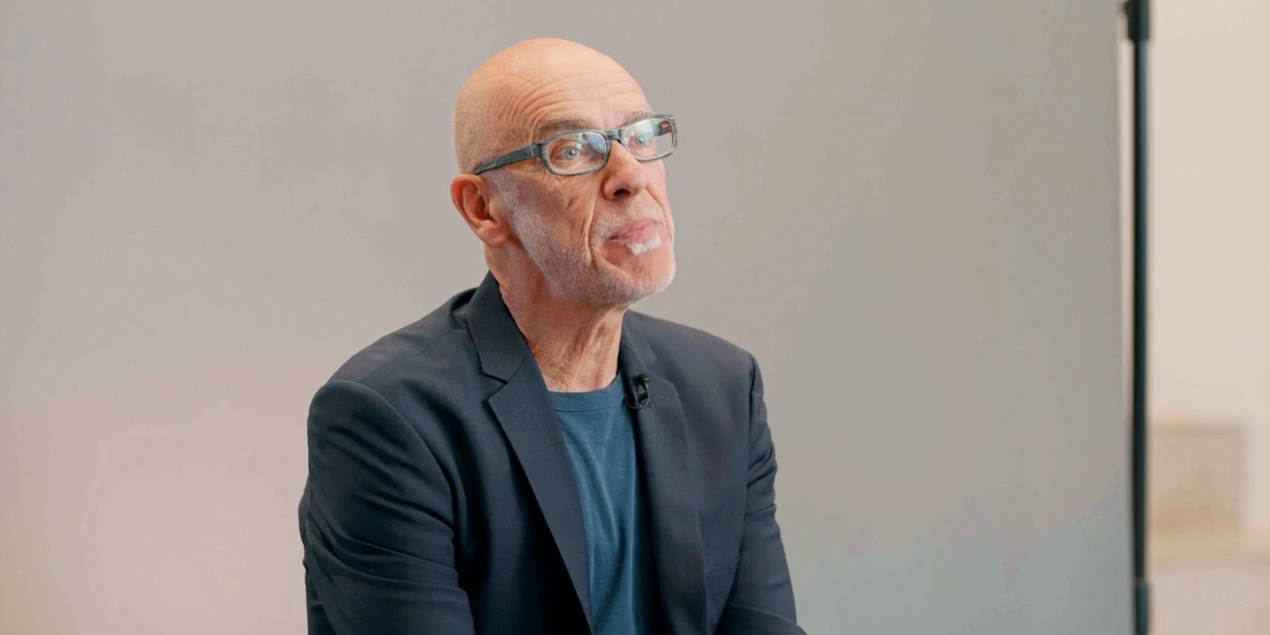 Porträt des wissenschaftlichen Mitarbeiters Mathias Voß vor einer grauen Leinwand