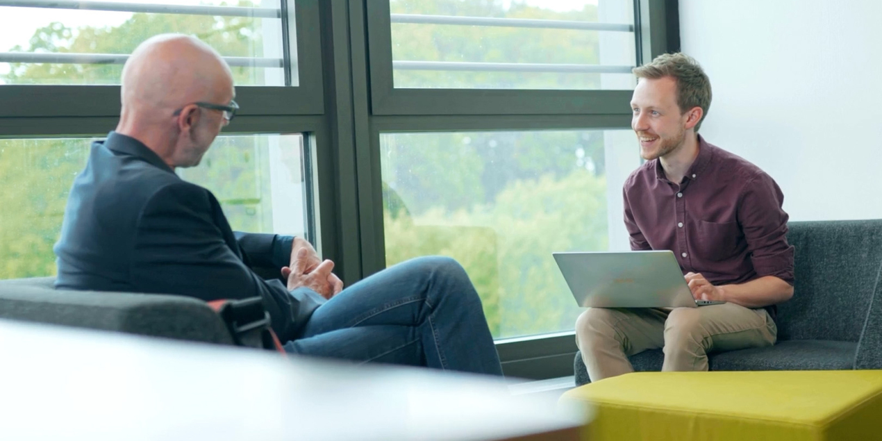 Matthias Voß und Nils Vetter sitzen sich in zwei Sesseln gegenüber und unterhalten sich