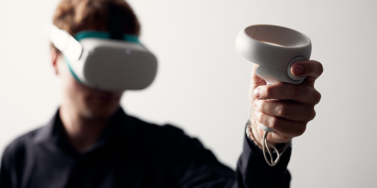 Ein Mitarbeiter des Projekts führt die Bedienung einer VR Brille und eines Controllers vor mit deren Hilfe die im Projekt entwickelten Übunsgsszenarien durchgeführt werden