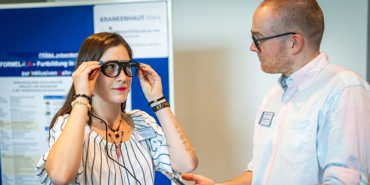 Eine Frau trägt eine Eye-Tracking-Brille. Sie schaut einen Mann an, der neben ihr steht