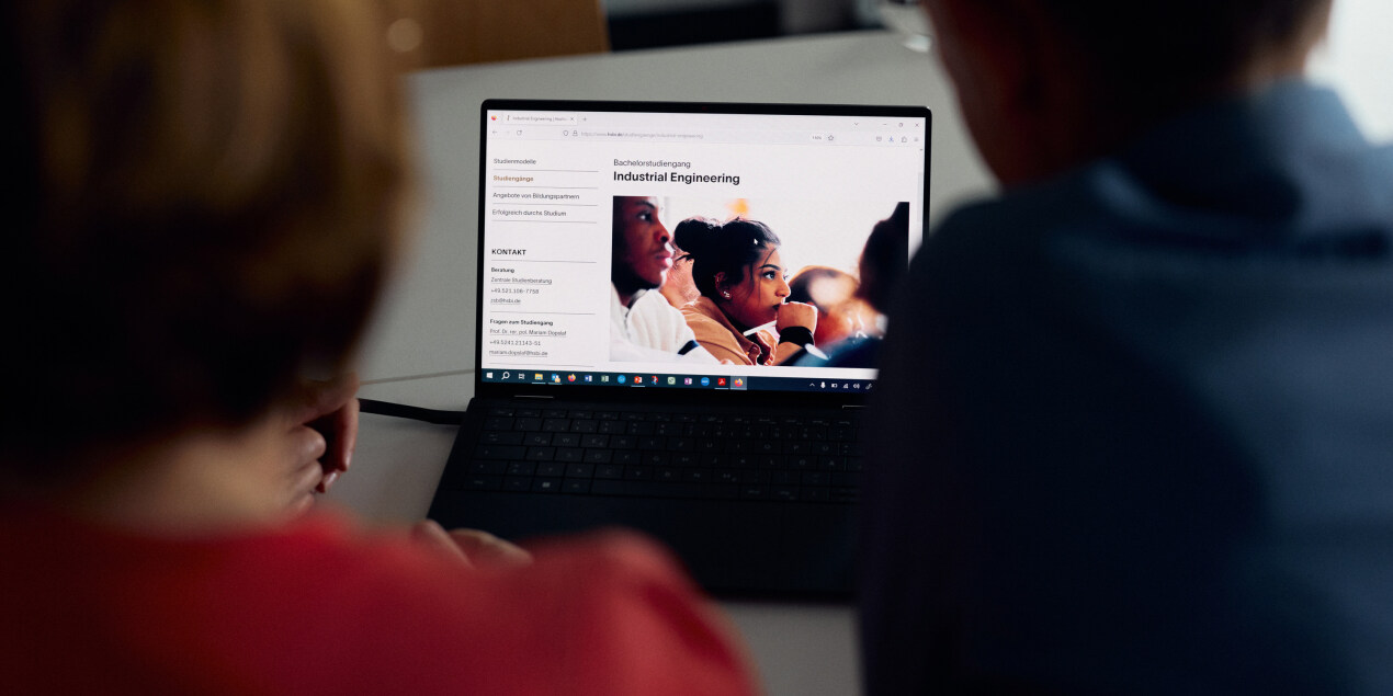 zwei Personen blicken auf enen Laptop