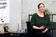 Eine Frau sitzt auf einem Stuhl und hält einen Vortrag.