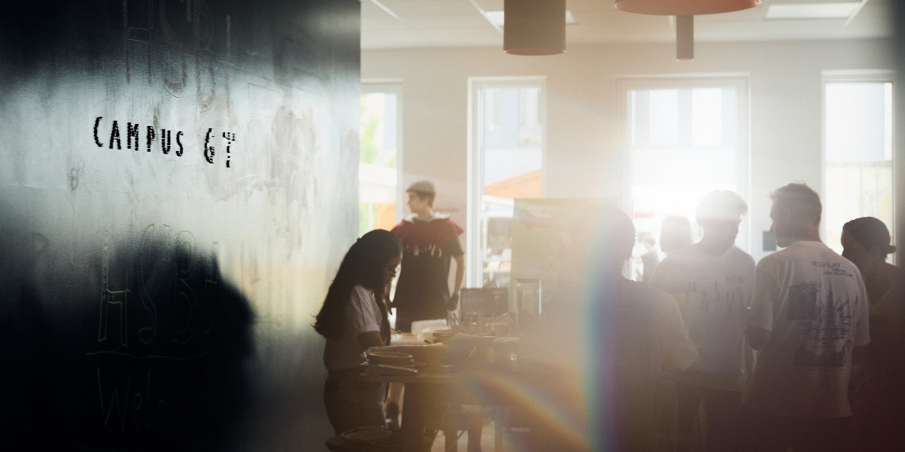 Im Aufenthaltsraum sind viele Menschen und die Sonne scheint rein