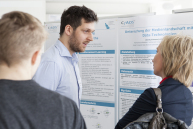 Ein Mann und eine Frau stehen vor einer Informationswand