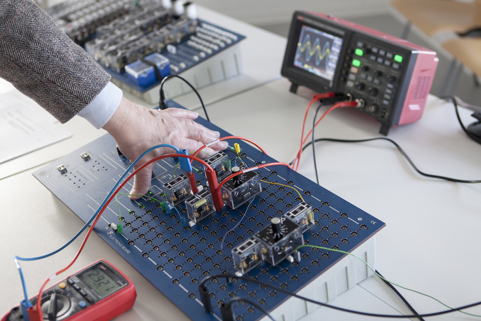 Auf einem Tisch liegt ein Elecotronic Board mit steckbaren Bauelementen für elektrische Versuche