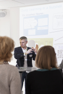 Ein Mann steht vor einer Leinwand mit der Überschrift Deep Learning