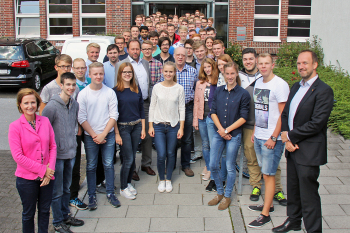 Alle Erstsemester stehen mit Dozenten vor dem Eingang zum Gebäude