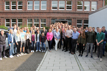 Gruppe von rund 90 Menschen steht vor dem Haupteingang am Studienort Gütersloh.
