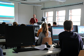 Mehrere Personen sitzen vor Computern.