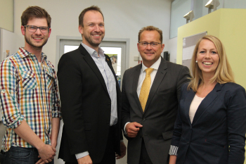 Willinghöfer, Reusch, Miksch und Proß stehen im Flur des Studienortes Gütersloh.