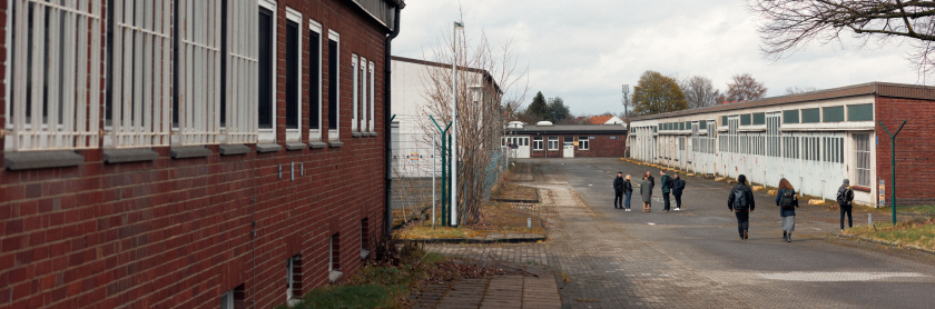Personen laufen auf dem Areal der ehemaligen Kasernen
