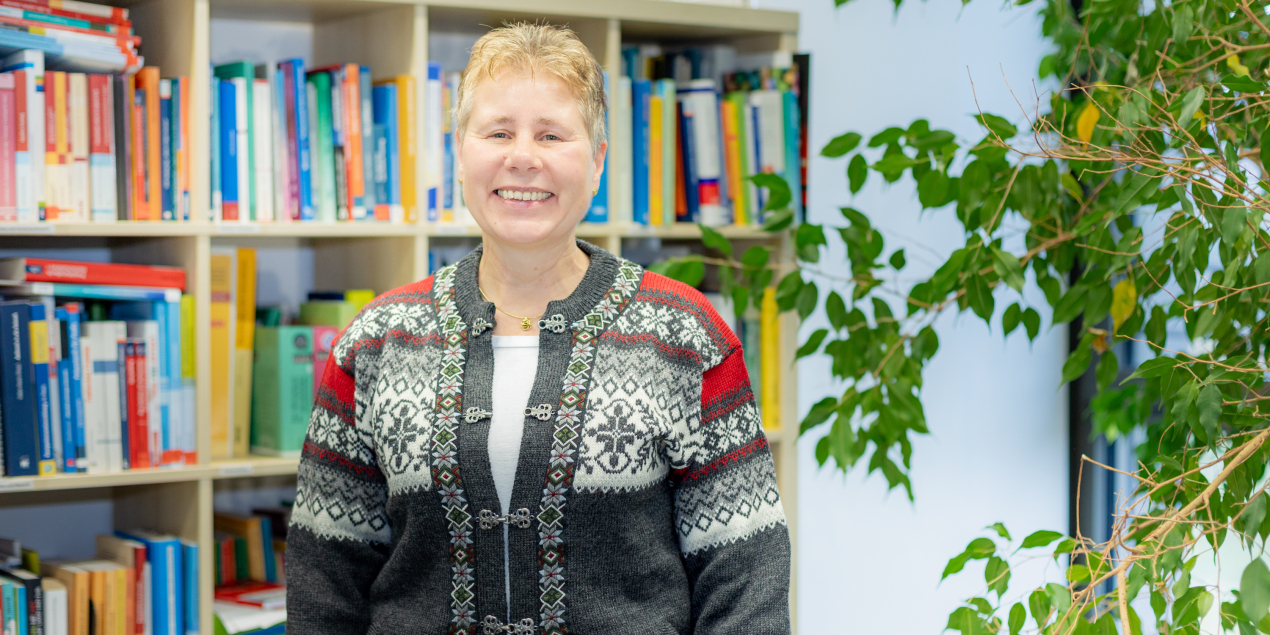 Martina Emke steht vor einem Bücherregal