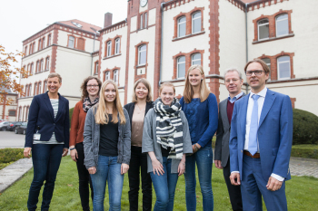 Personen stehen vor dem Hauptgebäude Campus Minden