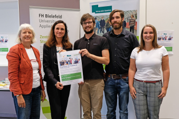 Fünf Personen stehen nebeneinander und blicken in die Kamera.