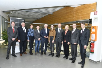 Sieben Männer und drei Frauen stehen nebeneinander