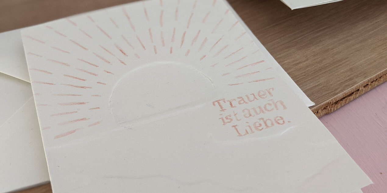 Eine weiße Karte mit der Aufschrift Trauer ist auch Liebe