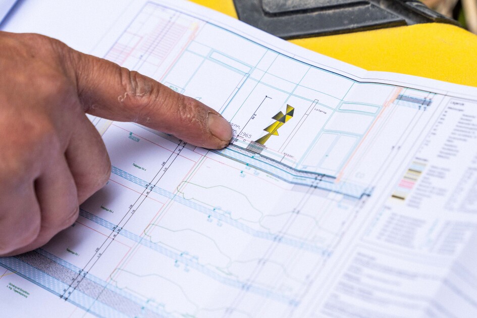 Eine Hand zeigt auf einen Ausschnitt eines Plans