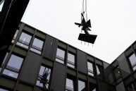 Die Skulptur von Hans Uhlmann hängt an einem Kran und wird zwischen den Gebäudeteilen in den Innenhog angeliefert