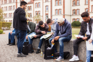 Einige neue Studierende schauen sich die Inhalte der Begrüßungstasche der Stadt Minden an.