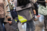 Eine Tasche hängt über der Schulter eines Studenten.