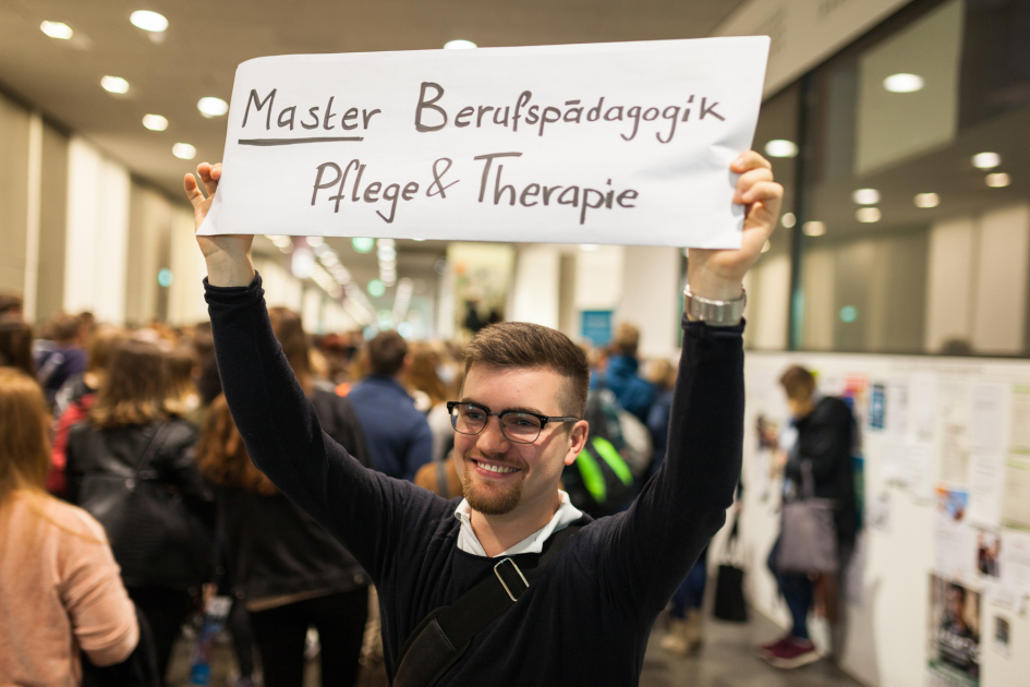 Ein Student hält ein Schild hoch