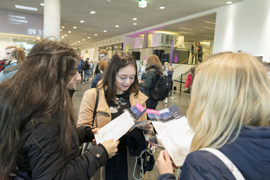 Drei Frauen schauen in Flyer