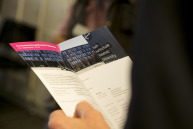 eine Hand hält einen geöffneten Flyer