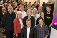 Vier Frauen und sechs Männer stehen vor eine Menschgruppe